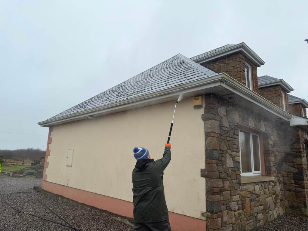 spraying gutters with cleaner
